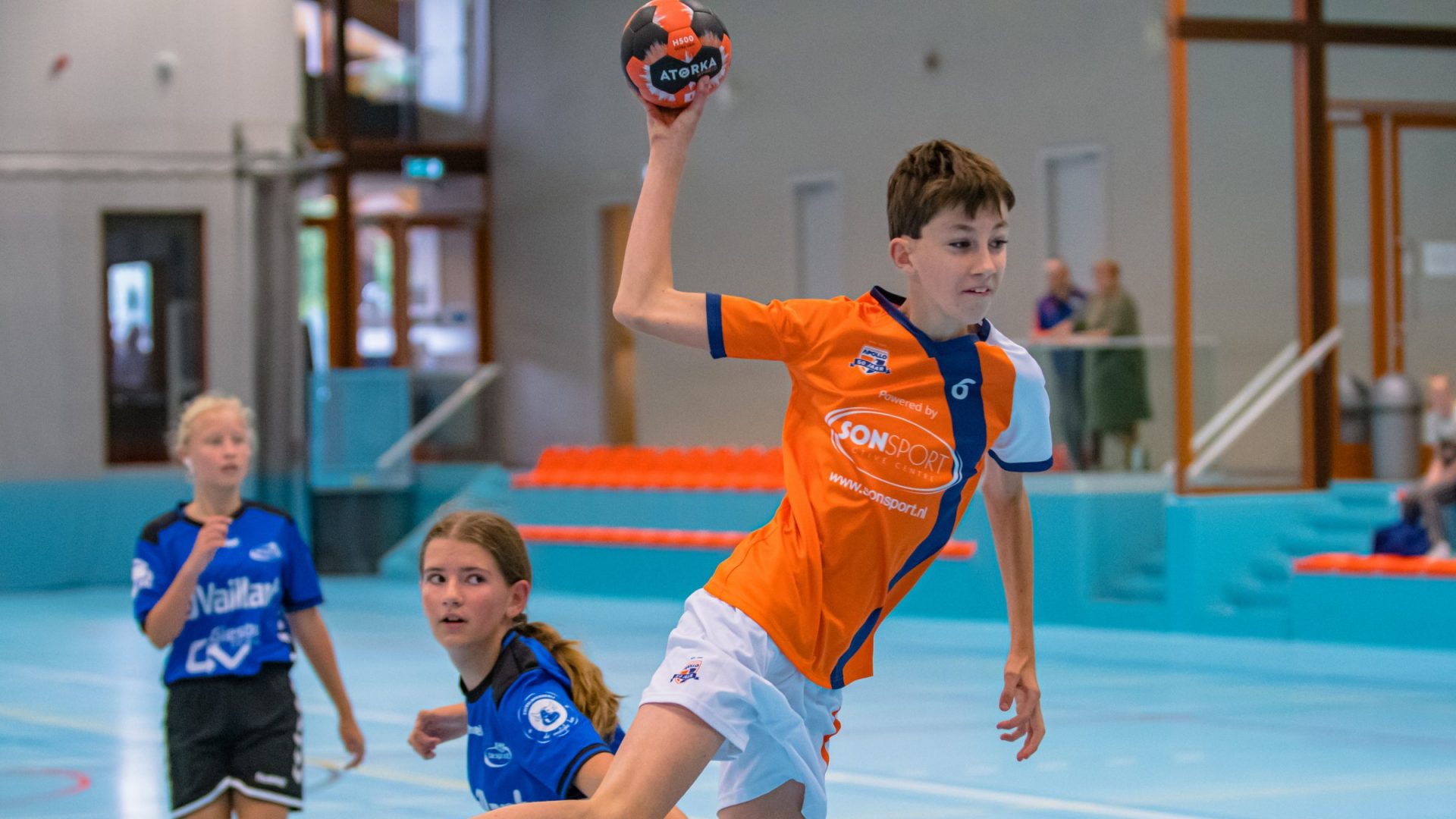 Jeugd van handbalvereniging aan het handballen
