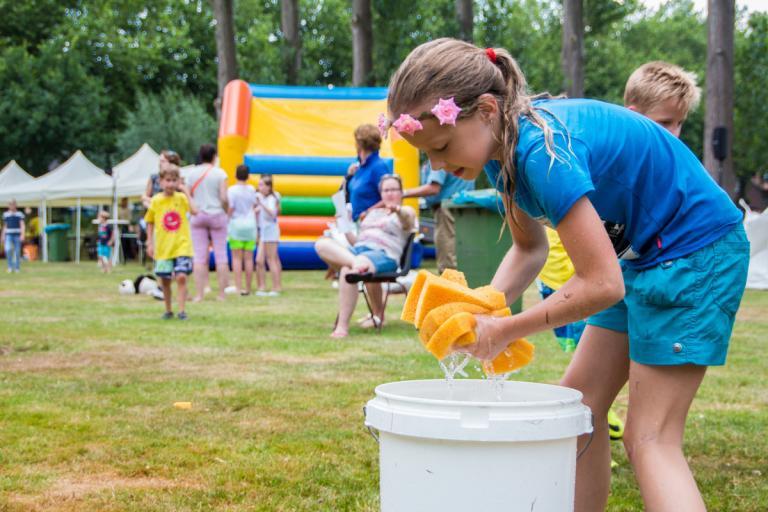 Kind wringt een natte spons uit bij het Zomerspektakel van jongerencentrum Oase