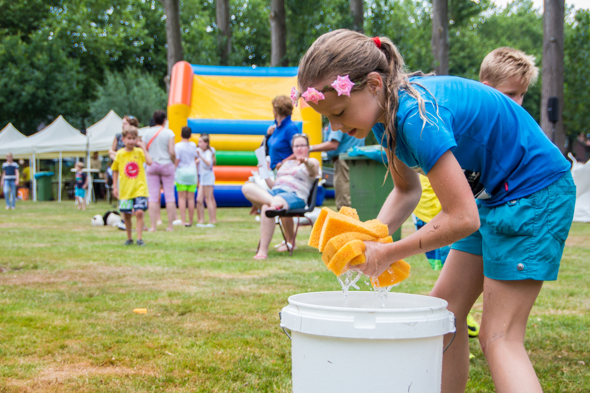 Kind wringt een natte spons uit bij het Zomerspektakel van jongerencentrum Oase