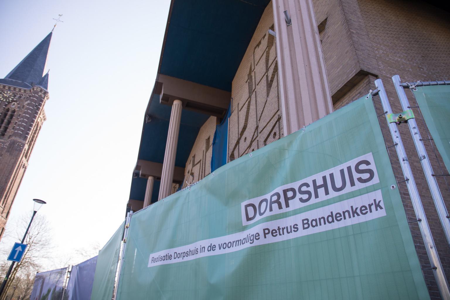 Het hek om de voormalige Sint-Petrus' Bandenkerk met een impressie van het nieuwe dorpshuis
