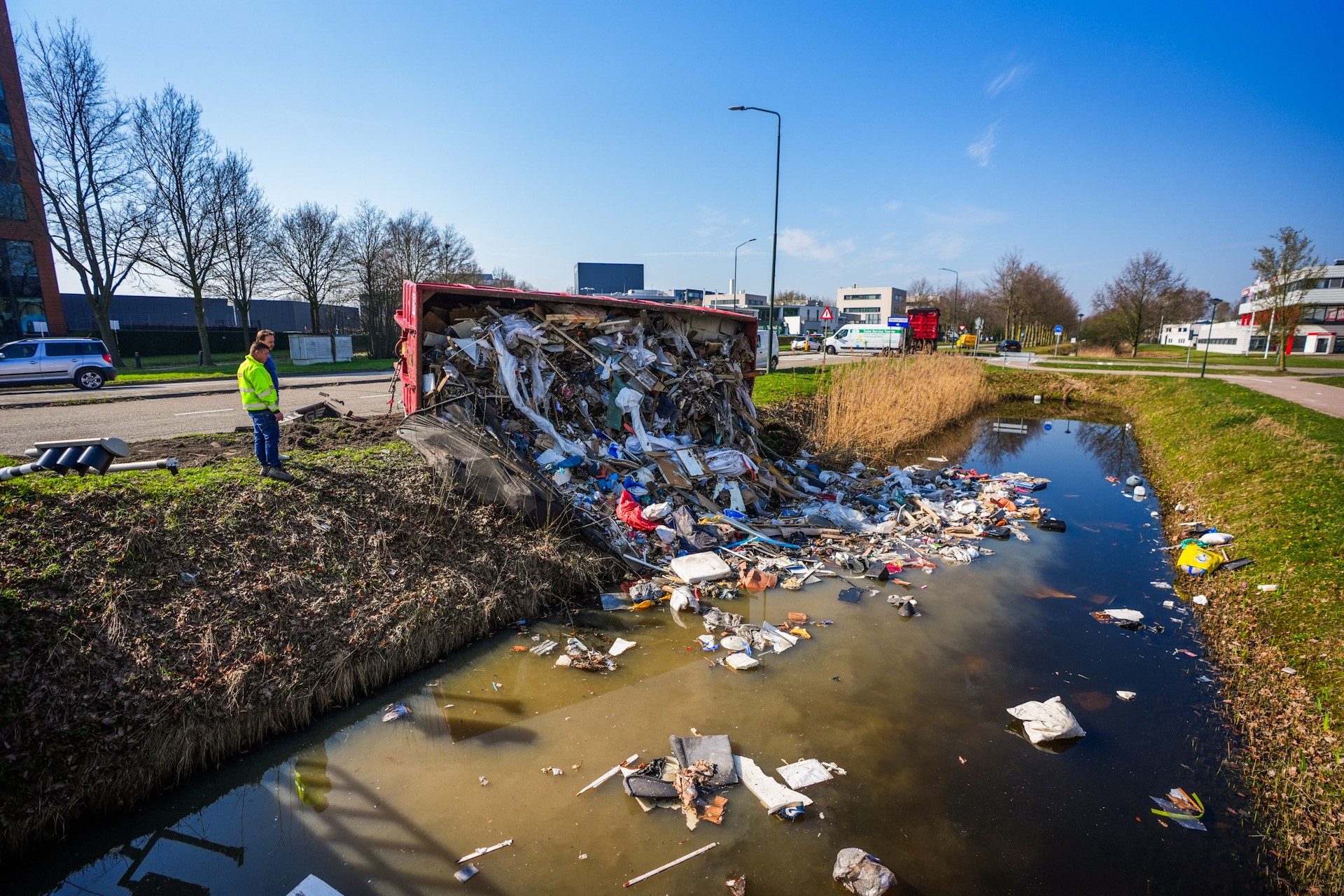 Container valt van trailer: puin in water, verkeerslicht omvergereden
