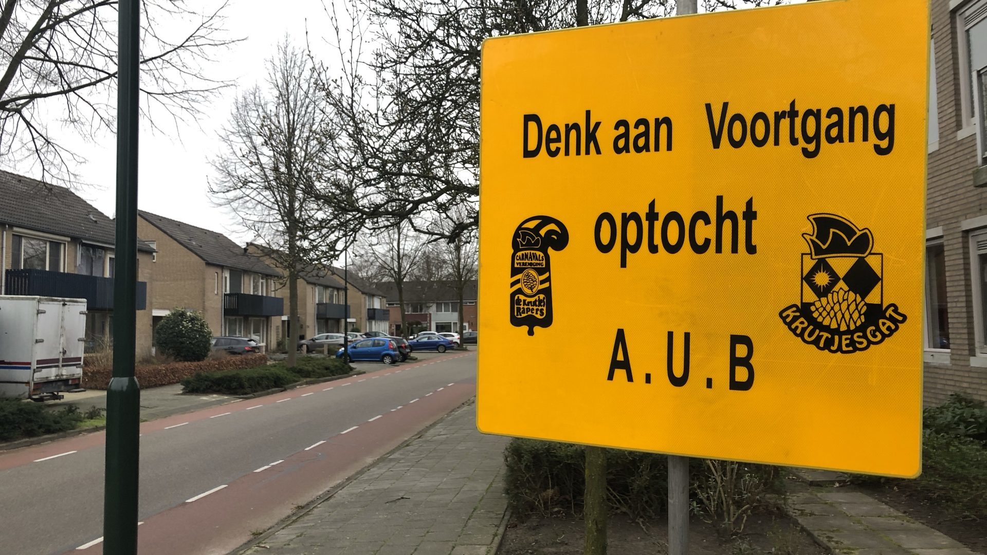 Het bord “denk aan voortgang optocht A.U.B.” aan het begin van de optocht