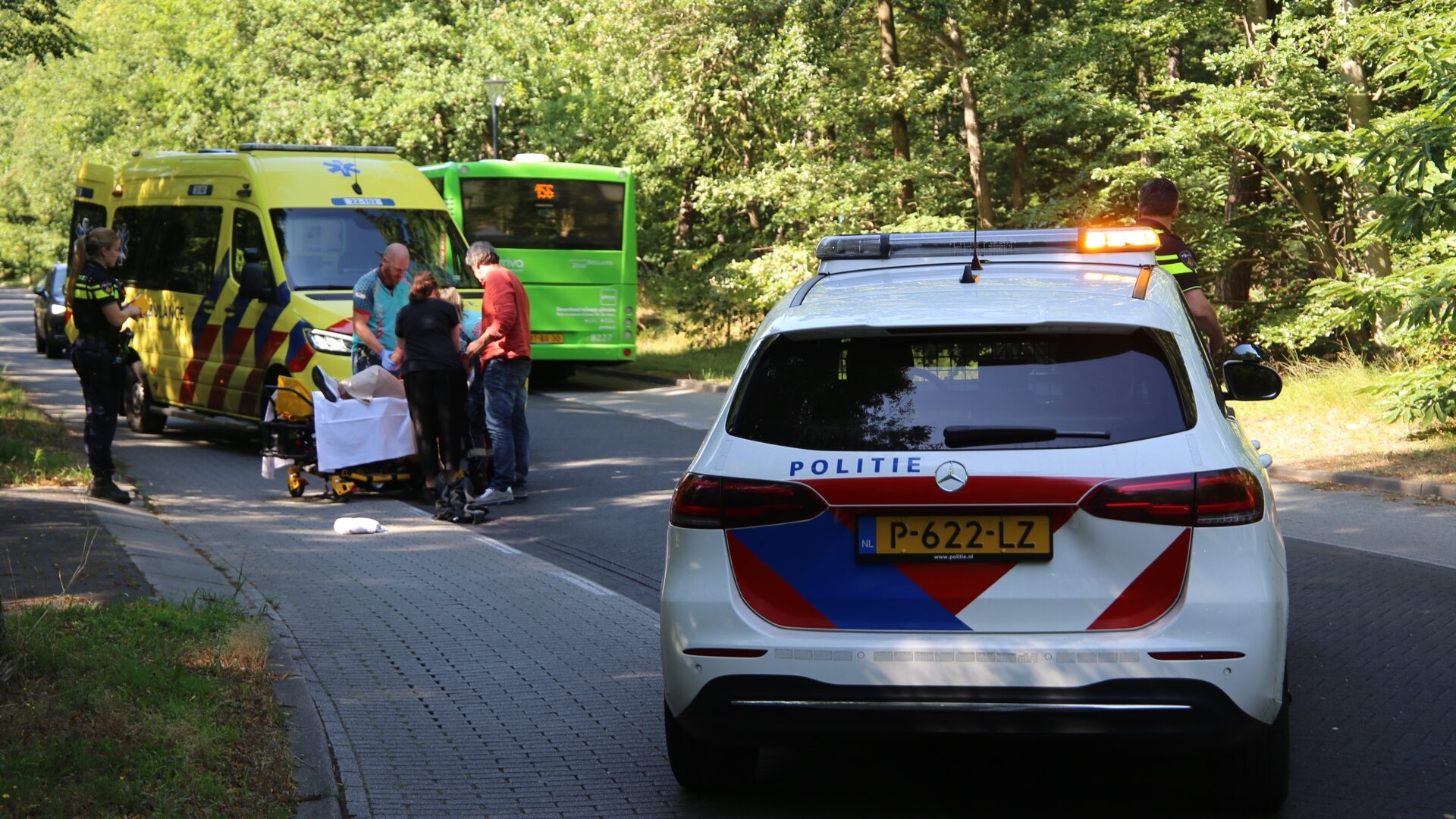 Fietsster wordt behandeld door het ambulancepersoneel op Hendrik Veenemenstraat