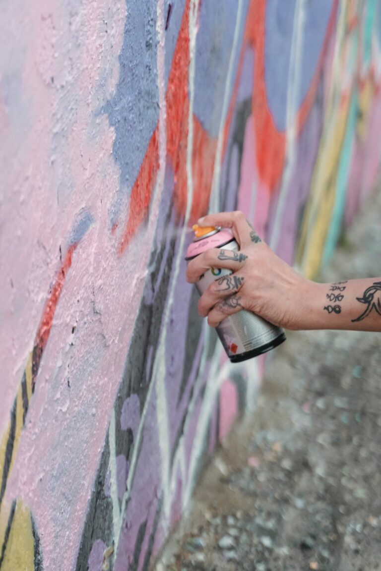 Graffiti die gespoten wordt op een muur